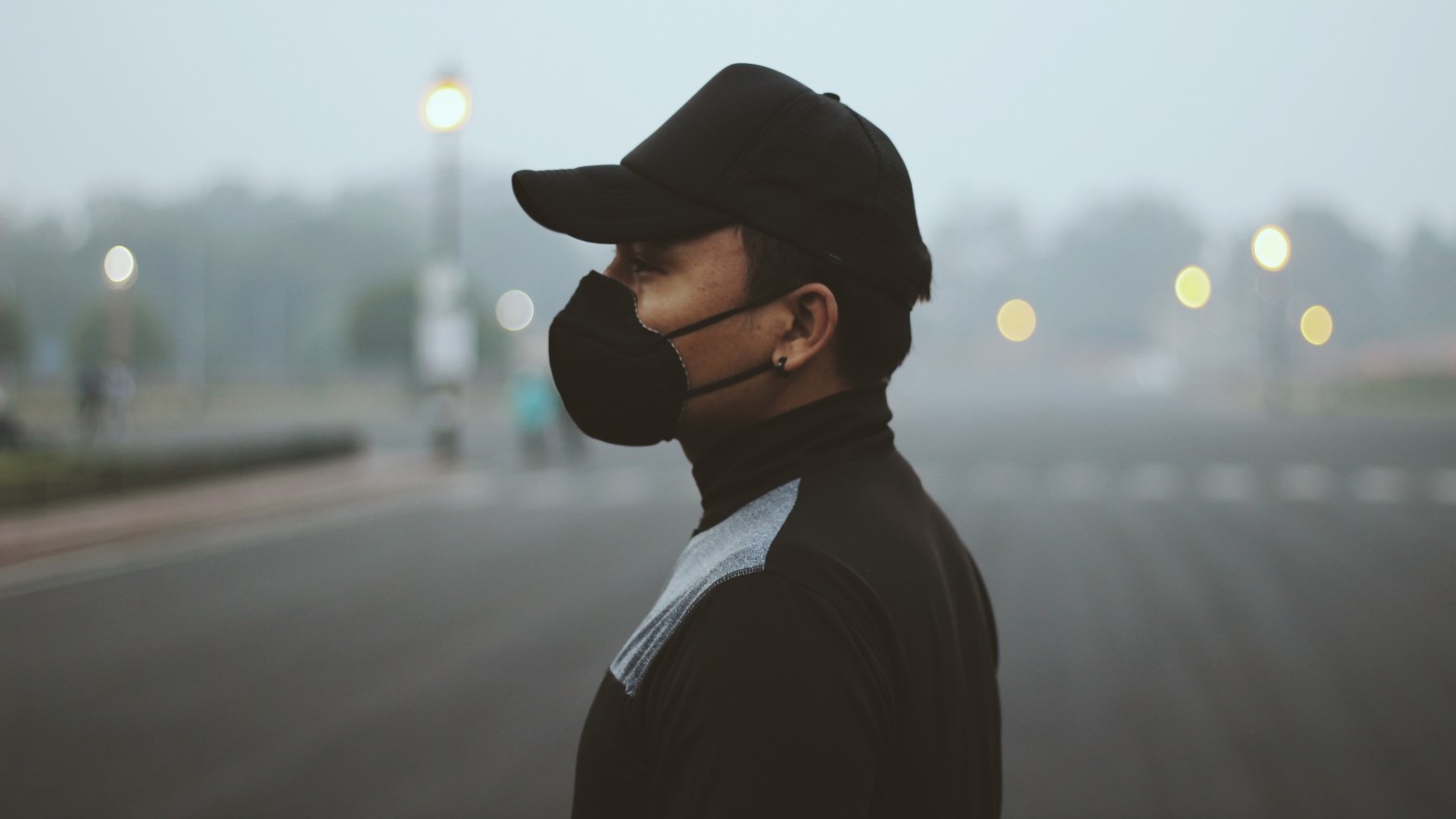 A person wearing a black mask with intense fogging in the background.